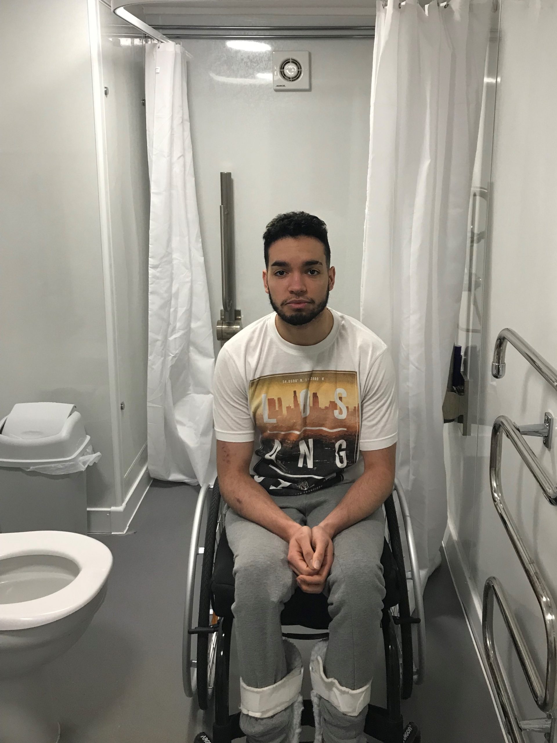 Luke in his wheelchair in his WashPod