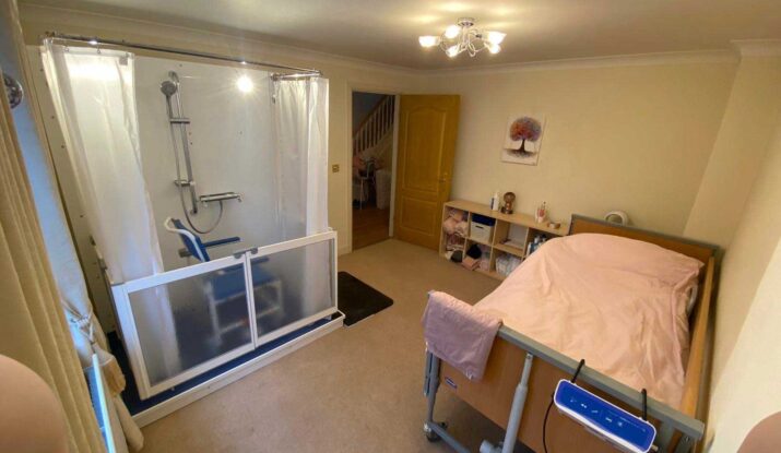 Photo of a bedroom with a Compact WashPod disabled shower along a wall