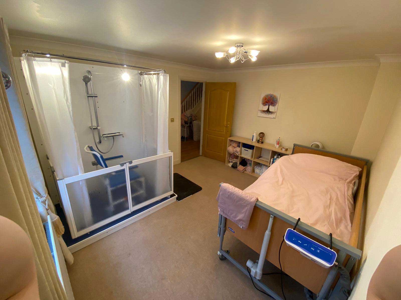 Photo of a bedroom with a Compact WashPod disabled shower along a wall