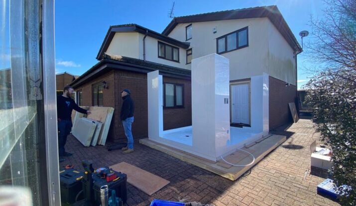 Photo showing the half erected external WashPod temporary disabled wetroom being built on the driveway of a house.
