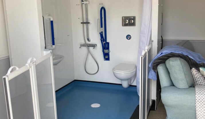 Photo of a Compact WashPod temporary disabled wetroom in the living room of an amputee