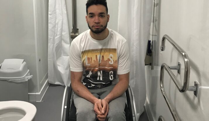 Photo shows Luke in his wheelchair in his Large External WashPod Temporary Disabled Wetroom
