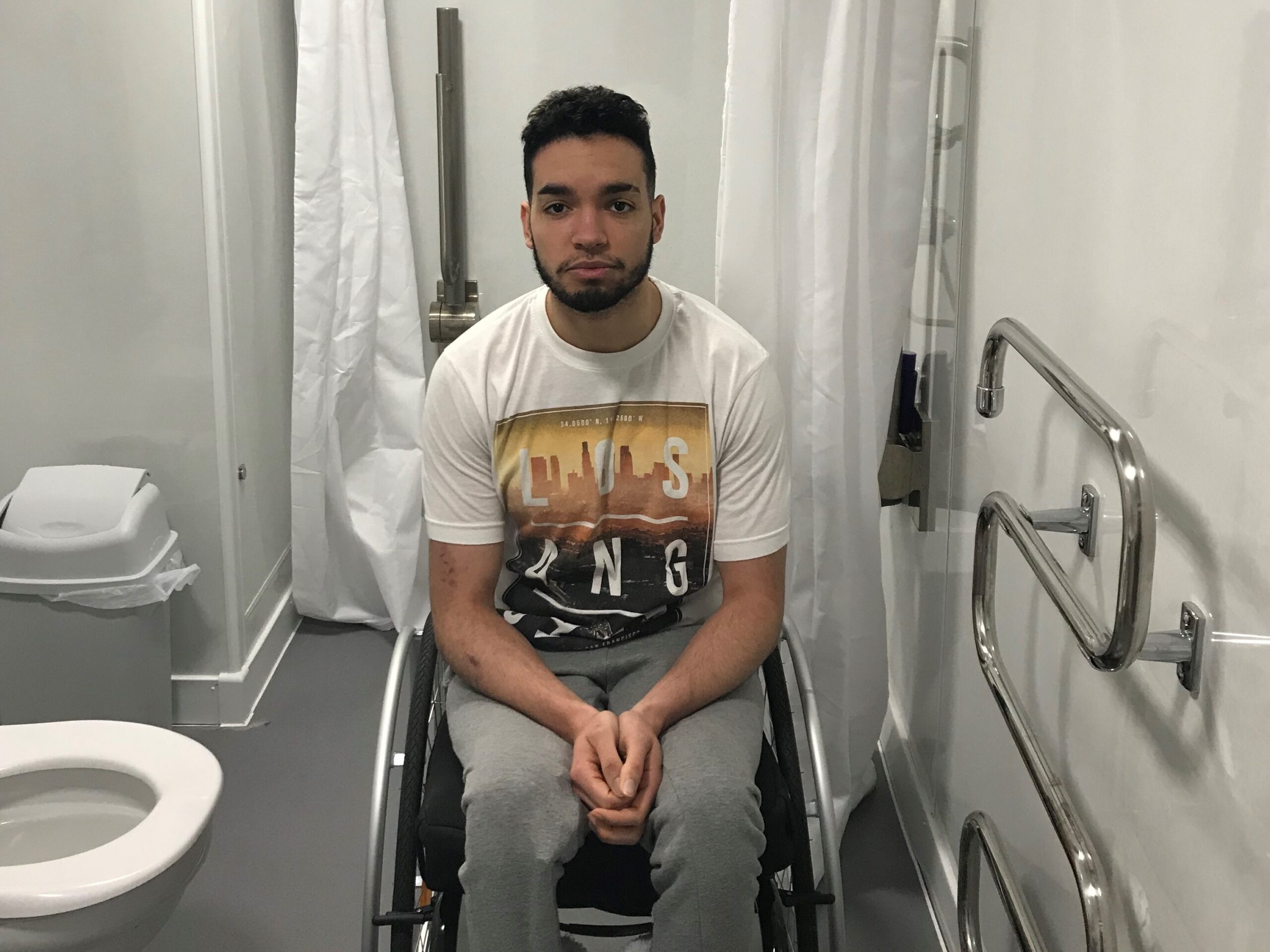 Photo shows Luke in his wheelchair in his Large External WashPod Temporary Disabled Wetroom