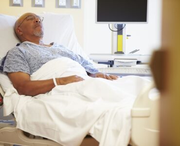 Senior Male Patient Resting In Hospital Bed